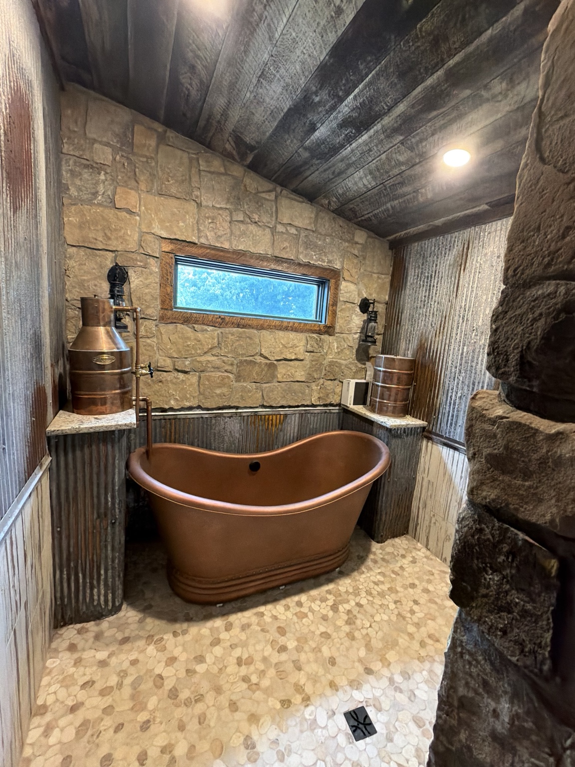 Copper soaking tub with stone walls and custom copper details