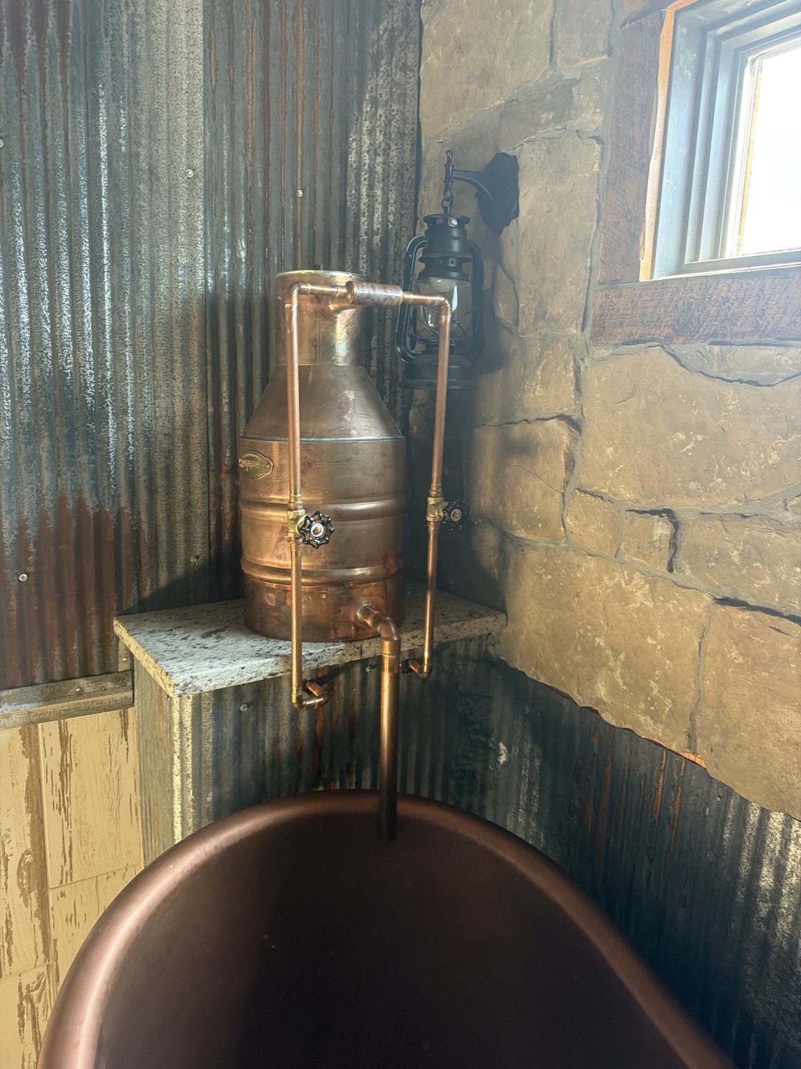 Custom copper vessel and pipe detail beside soaking tub